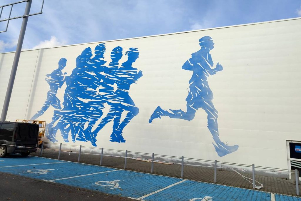 Reklamowy mural o tematyce sportowej namalowany dla Decathlon w Poznaniu