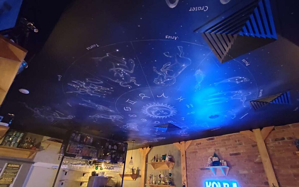 Malowanie znaków zodiaków na suficie w Kolba pub w Krakowie, ciekawy mural na suficie w klimacie fantasy